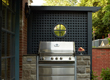A built-in bbq surrounded by stone and gorgeous blue latticework